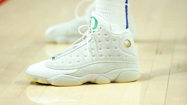 View of white and green Air Jordan shoes.